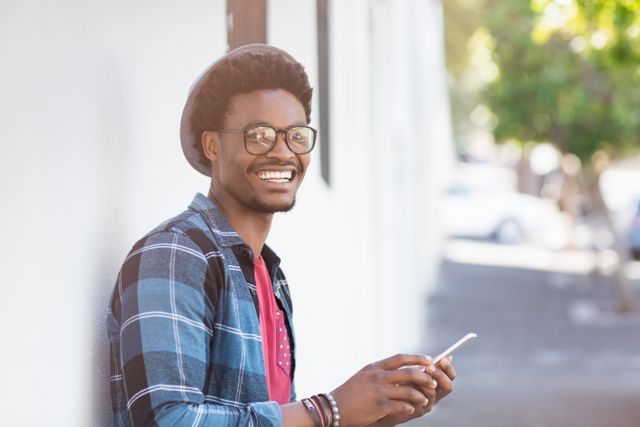 Portrait of happy young man using mobile phone