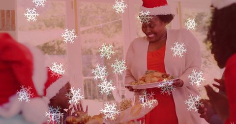 Family Celebrating Christmas Dinner with Santa Hats and Snowfall Decor