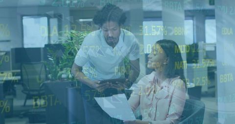 Colleagues analyzing business reports with stock data overlay