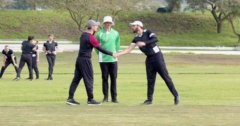 Cricket players exhibit sportsmanship with handshake on pitch
