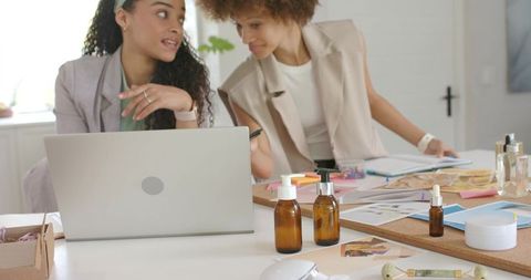 African american women collaborating on cosmetic product development in creative studio