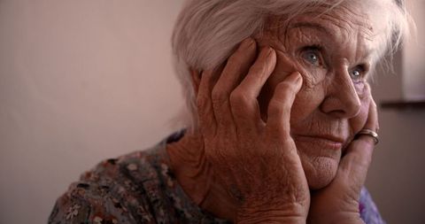 Thoughtful Elderly Woman Reflecting Daylight Indoors