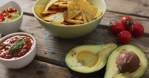 Serving fresh halved avocados with tortilla chips, salsa and guacamole for casual party spread