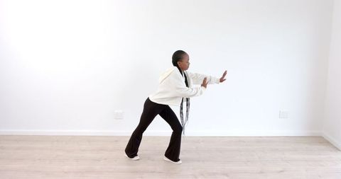 Young Woman Practicing Dance Moves in Bright Minimalistic Space