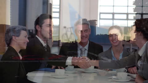 Business Handshake with Cityscape Overlay at Dusk