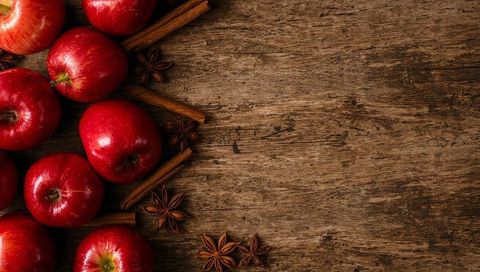 Red Apples with Cinnamon and Star Anise on Rustic Wood Background with Copy Space for Autumn