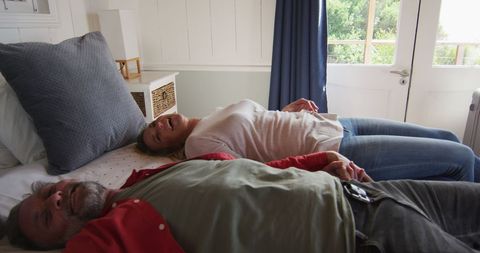 Mature Couple Relaxing on Bed in Bright Hotel Room