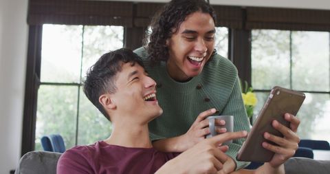 Happy Diverse Male Couple Enjoying Tablet in Living Room - Download Free Stock Images Pikwizard.com