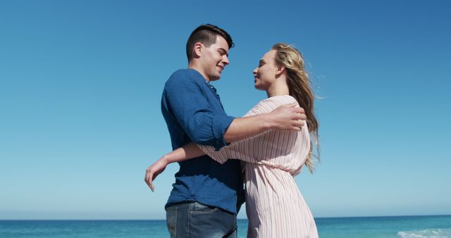 Happy couple embracing on beach under clear blue sky - Download Free Stock Images Pikwizard.com