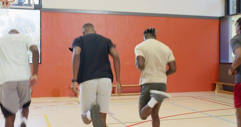 African american men doing butt kicks and lunges in gym group conditioning drill