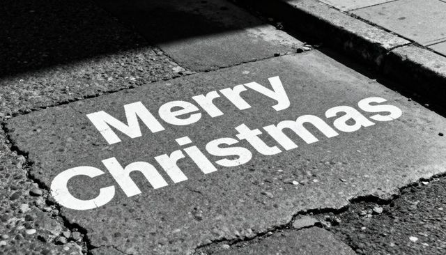 Merry christmas stencil on cracked concrete sidewalk monochrome urban typography