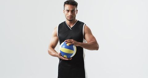 Athletic Man Holding Volleyball Preparing for Game on White Background
