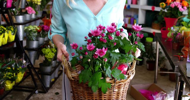 Female florist holding bunch of flowers in flower shop