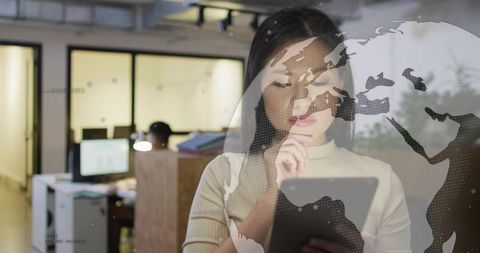 Asian Businesswoman Using Tablet with Futuristic Overlay in Office