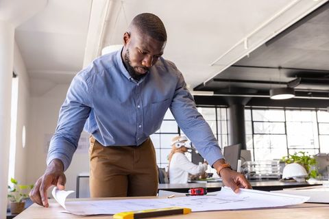 Architects analyzing blueprints in modern office environment