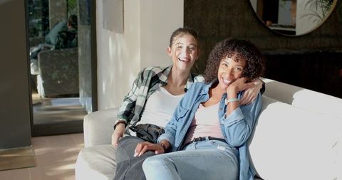 Diverse Female Friends Smiling on Sofa in Modern Living Room