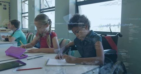 Inclusive classroom learning with wheelchair student and classmates writing at desks