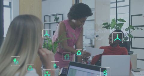 Coworkers collaborating on sustainable office project with green icons and indoor plants