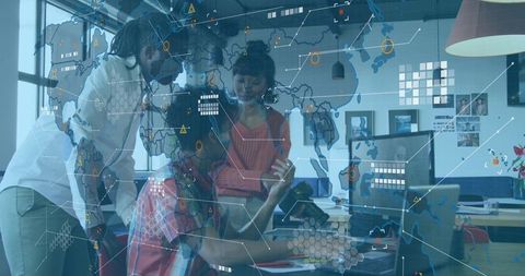 Diverse team collaborating on global data visualization with laptop and tablet