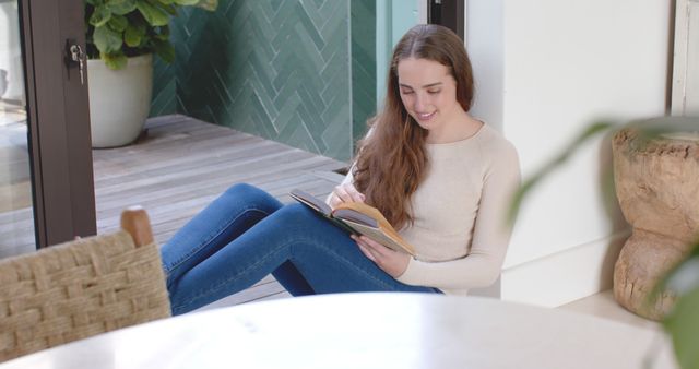 Young Woman Reading Book Relaxing Indoors in a Modern Home - Download Free Stock Images Pikwizard.com