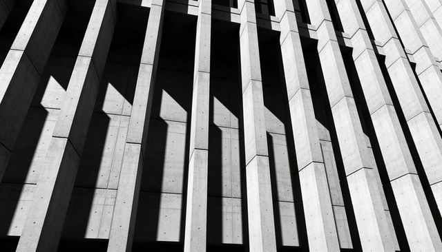 Brutalist Concrete Facade with Dramatic Vertical Shadows, High-Contrast Monochrome Geometry