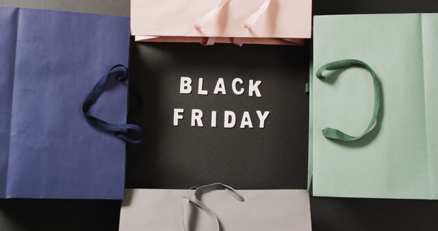 Black friday text in white on black with coloured gift bags. Black friday, shopping, sale and retail concept digitally generated image.