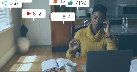 Content creator managing social media metrics and notes at home