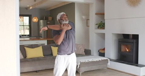 Senior african american man stretching in cozy living room