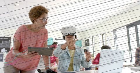 Teacher guiding student using vr headset for interactive learning in modern classroom lab