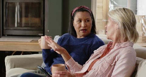 Diverse Female Friends Talking with Coffee on Cozy Couch