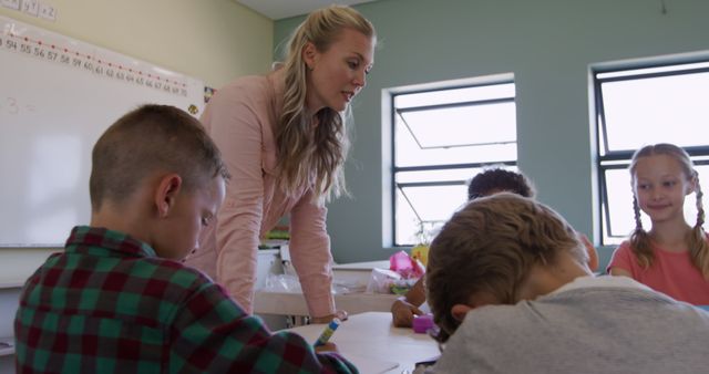 Dedicated Female Teacher Helping Students in Classroom - Download Free Stock Images Pikwizard.com