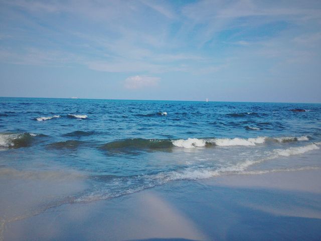 Calm Ocean Waves Rolling onto Sandy Beach under Blue Sky - Download Free Stock Photos Pikwizard.com