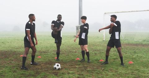 Diverse Male Soccer Teammates Warming Up on Field