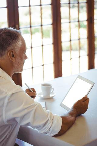mature man sitting in cafe with transparent tablet screen - Download Free Stock Videos Pikwizard.com