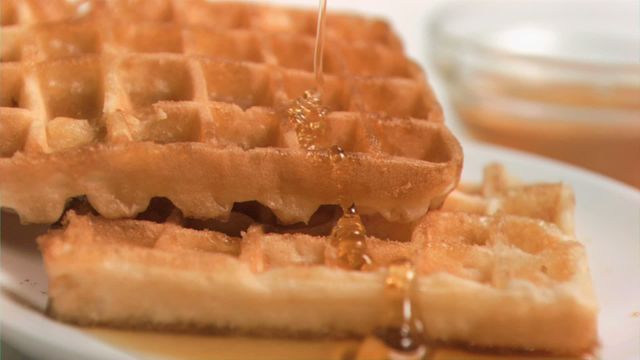 Golden maple syrup flowing slowly over crispy homemade waffles drives enjoying a warm, comforting breakfast on lazy mornings. Ideal augmented for food blogs, advertisements, visually appealing cooking tutorials, recipes, lifestyle publications emphasizing indulgent breakfast or brunch options.