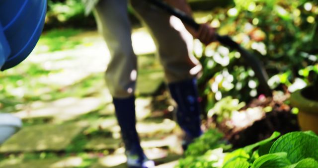 A person is gardening, wearing boots and using a tool to work on plants, with copy space - Download Free Stock Photos Pikwizard.com