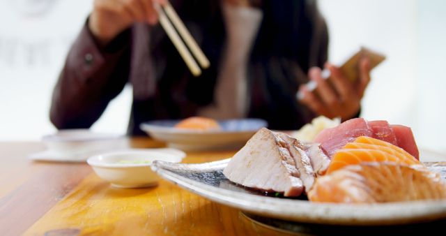 Woman Modern Dining Sushi and Using Phone with Chopsticks - Download Free Stock Images Pikwizard.com