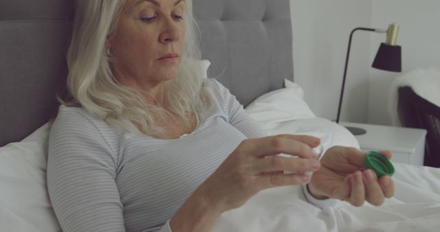 Elderly Woman Taking Medication in Bed in Cozy Room - Download Free Stock Images Pikwizard.com