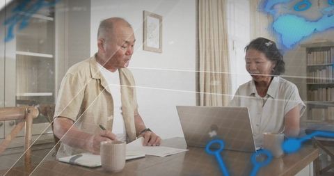 Senior asian couple managing retirement finances using laptop, reviewing documents at home