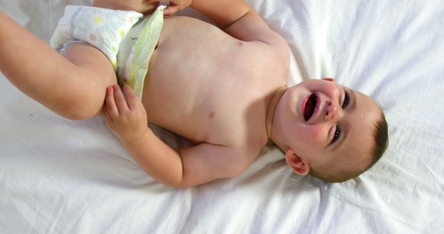 Cute baby laughing and lying on a bed