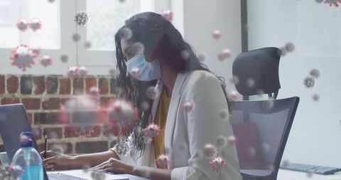 Businesswoman in mask working with covid-19 cells overlay
