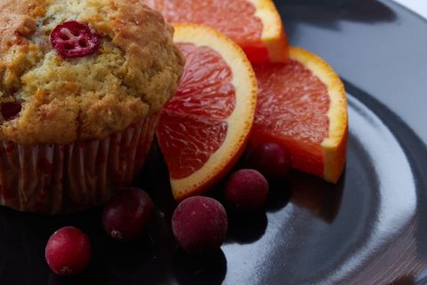 Freshly baked cranberry orange muffin with fruit garnish