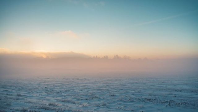 Enchanting Sunrise Over Misty Snow-Covered Landscape