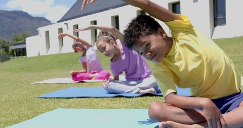 Children Practicing Outdoor Yoga on Sunny Day with Mountain Backdrop