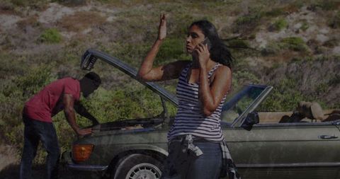 Distressed couple seeking roadside assistance with broken car