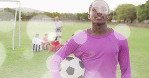 Confident Goalkeeper Holding Soccer Ball on Field