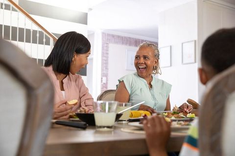 Diverse Family Joyfully Sharing Meal at Home Dining Table