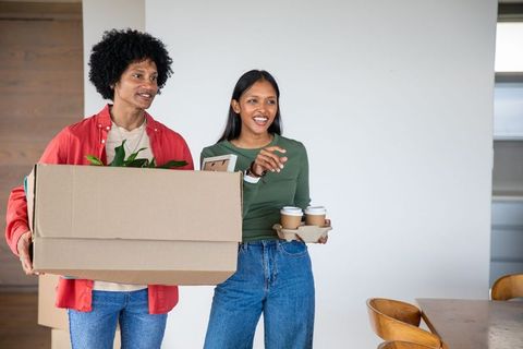 Excited couple moving into new home with boxes and coffee