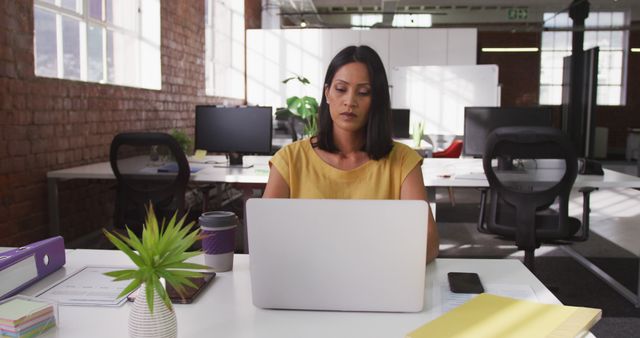 Focused Woman Working on Laptop in Modern Office Space - Download Free Stock Images Pikwizard.com