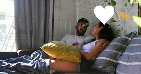 Couple Embracing on Sofa with Financial Data Overlay